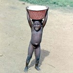 Also taken at Lokoja, this small girl was carrying a large bowl of water but seemed to have lost her companions in the busy crowds milling around the approach to the river ferry - east bank. January 1973.