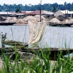 This photo was taken when approaching Lagos on the road from Ibadan, where in places the road ran close to coastal waterways. Sand was dug, often by hand, from the bed of the waterway and then transported by boat to points where it could be collected for use in the building industry. 1977.